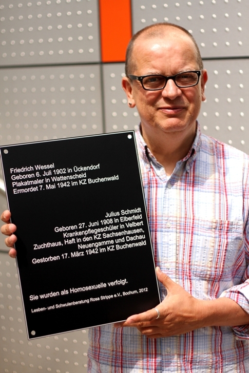 Jürgen Wenke präsentiert die Erinnerungstafel, die an Verfolgung und Ermordung zweier Homosexueller Männer durch das NS-Terrorregime erinnert. (Foto  Dennis Luc)